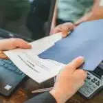 A woman giving mortgage papers to a man