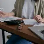 A lady sititng on chair doing some calculations